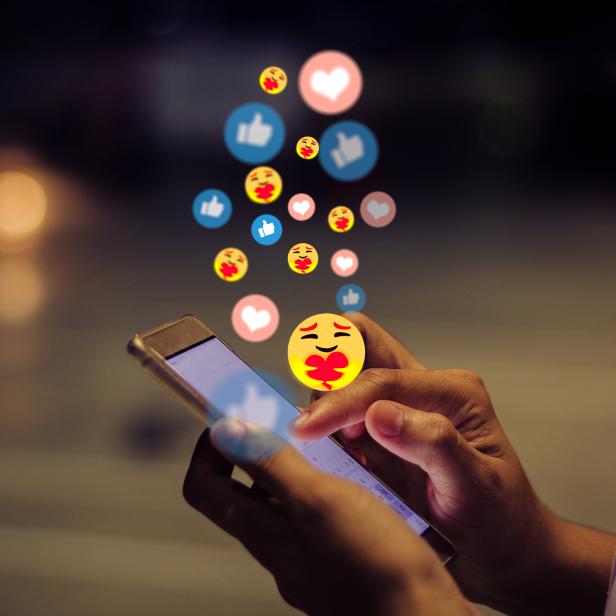 Eine Person benutzt ein Smartphone, umgeben von animierten Emojis und Likes.