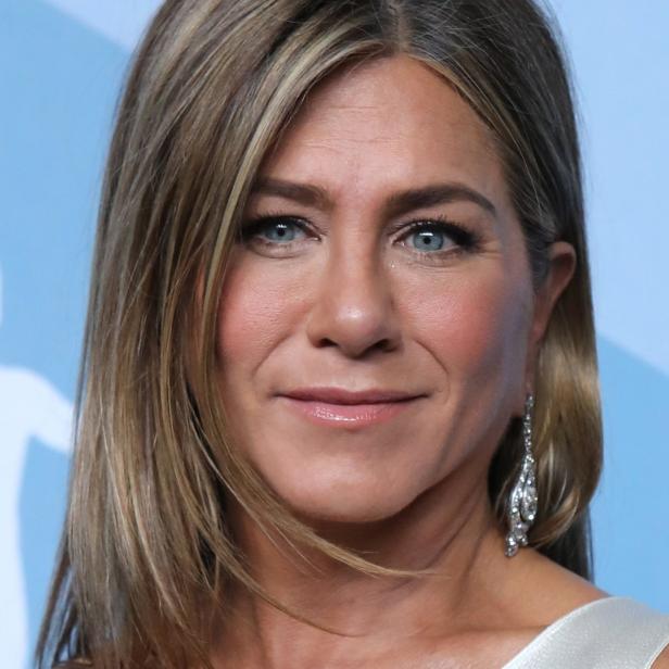 Nahaufnahme von Jennifer Aniston mit blonden Haaren und einem silbernen Ohrring.