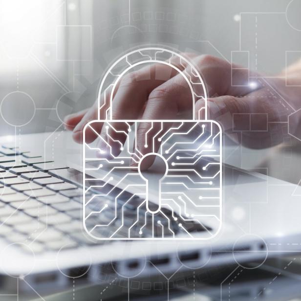 Cyber security and protection of private information and data concept. Bright big lock with integrated circuit on it. Person using computer on background. Safe payments concept.