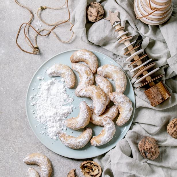 Vanillekipferl, traditionelles Weihnachtsgebäck, auf einem Teller mit Puderzucker.