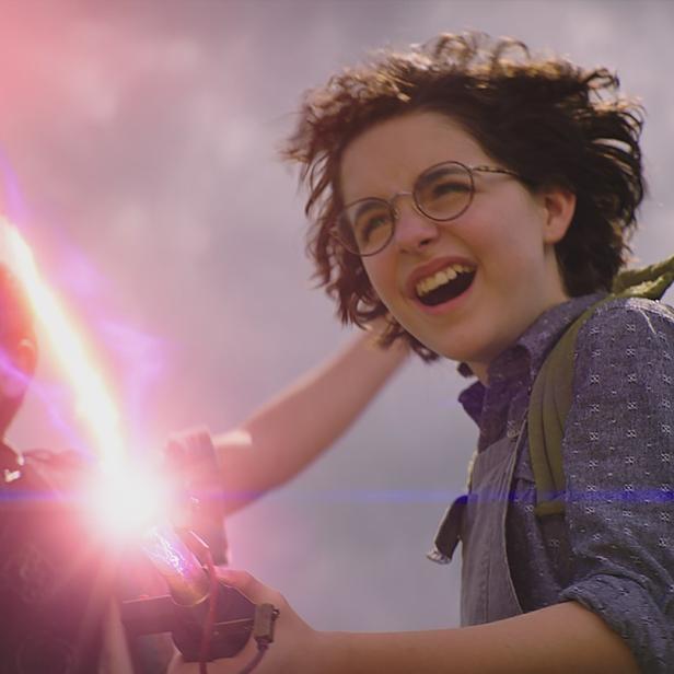 Zwei Kinder, mit Ghostbusters-Ausrüstung ausgestattet, strahlen mit ihren Protonenstrahlern.