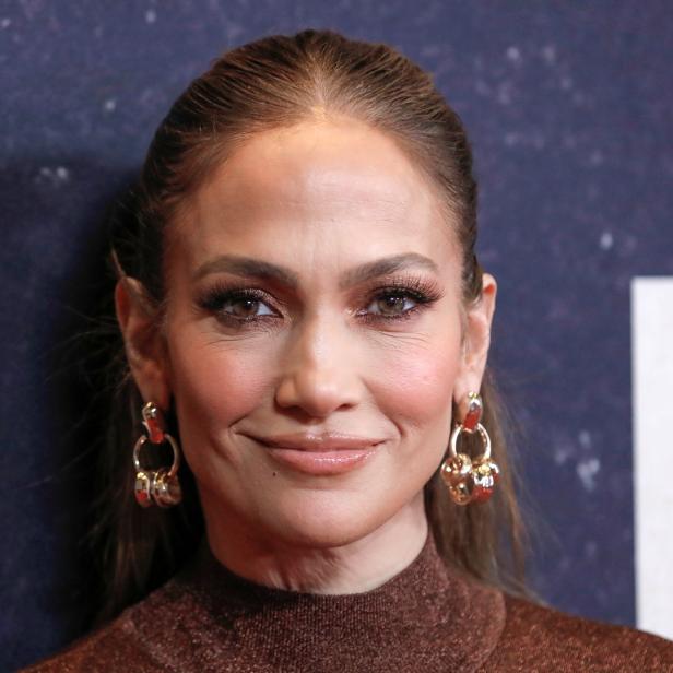 Jennifer Lopez mit braunem Rollkragenpullover und auffälligen Ohrringen.
