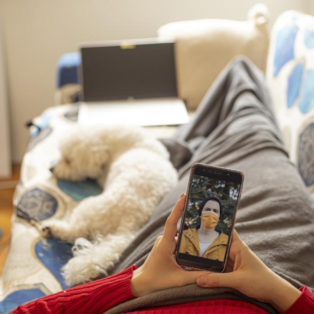 Junge Frau telefoniert per Videoanruf mit ihrem Freund über das Mobiltelefon.