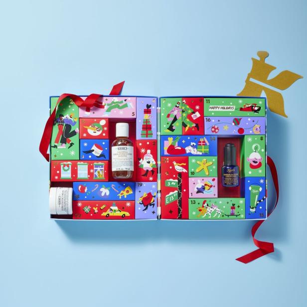 Ein geöffneter Kiehl's Adventskalender mit verschiedenen Hautpflegeprodukten und festlichen Illustrationen.
