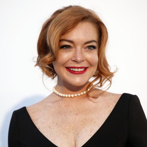 Ein Porträt von Lindsay Lohan mit roten Lippen und einer Perlenkette.