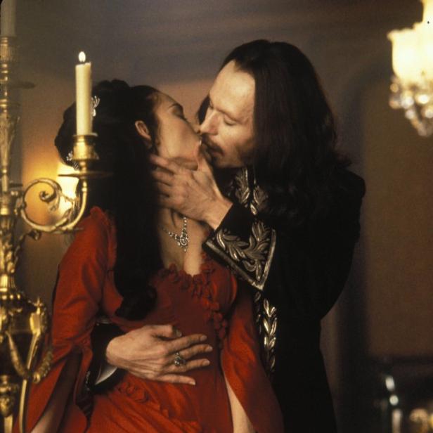 Gary Oldman als Graf Dracula küsst eine Frau in rotem Kleid.