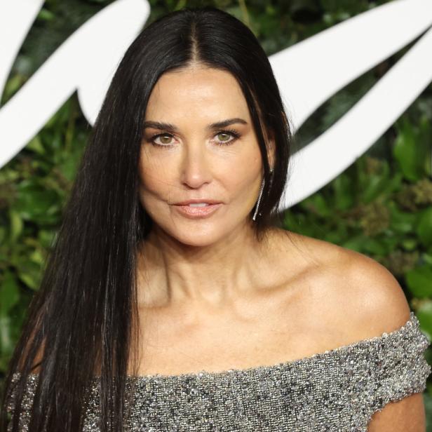 Demi Moore posiert in einem silbernen Kleid auf dem roten Teppich.