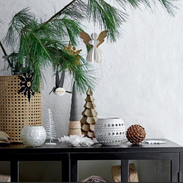 Dekorative Weihnachtszweige mit Schmuck auf einem schwarzen Schrank.