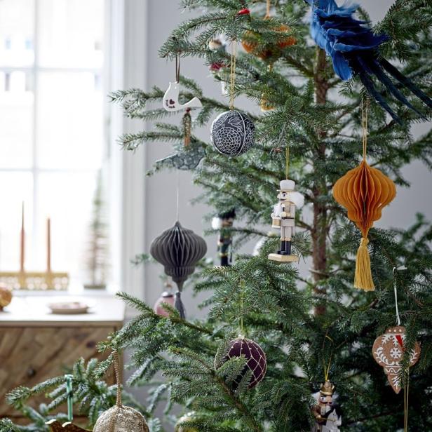 Ein geschmückter Weihnachtsbaum mit verschiedenen Ornamenten, darunter ein blauer Vogel und Nussknackerfiguren.