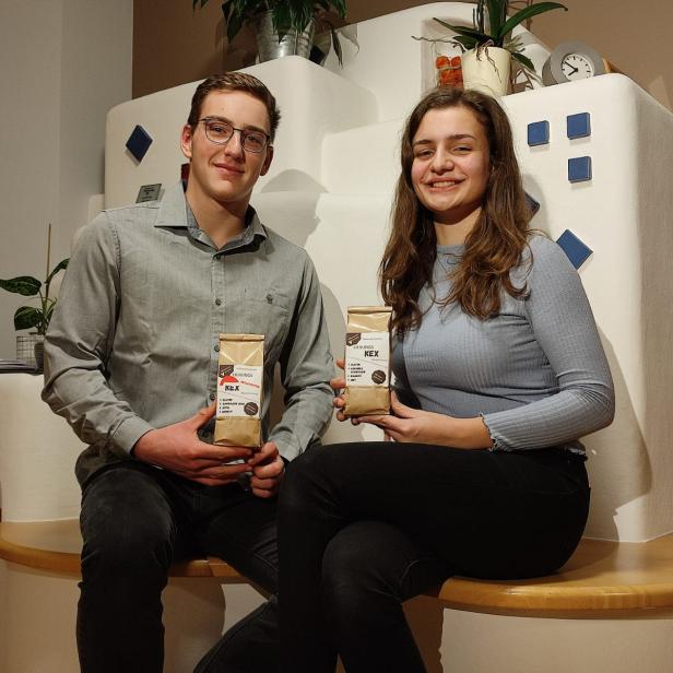 Ein junger Mann und eine junge Frau präsentieren Kaffeepackungen der Marke „Lieblings KEX“.