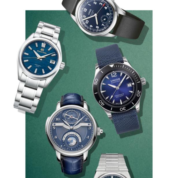 Eine Auswahl verschiedener Armbanduhren mit blauen Zifferblättern auf einem grünen Hintergrund.