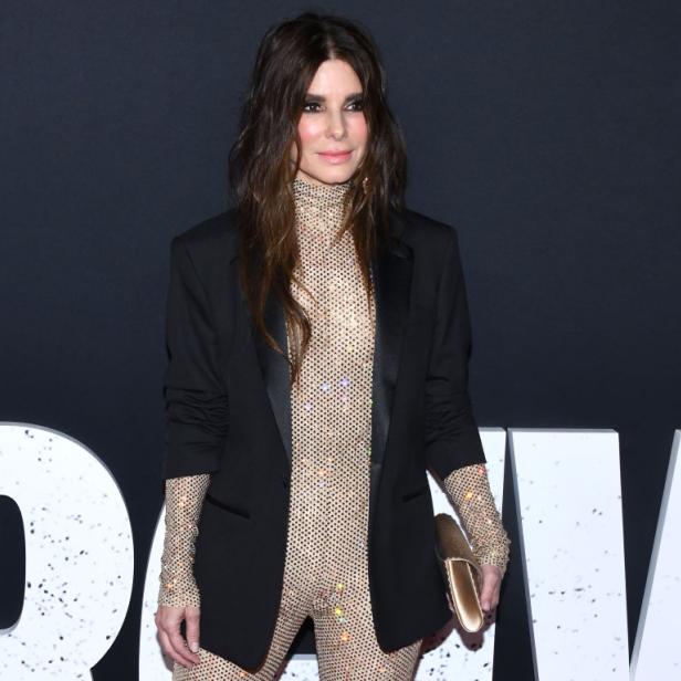 Sandra Bullock posiert in einem glitzernden Overall und Blazer auf dem roten Teppich.