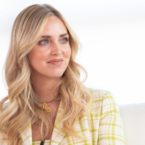 Chiara Ferragni mit blonden, gewellten Haaren und einem gelb-weiß karierten Blazer.