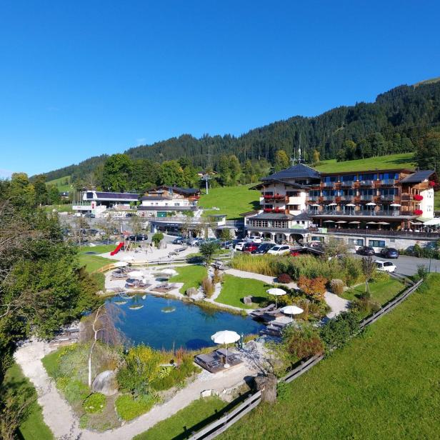 Ein Hotelresort mit einem See und Bergen im Hintergrund.