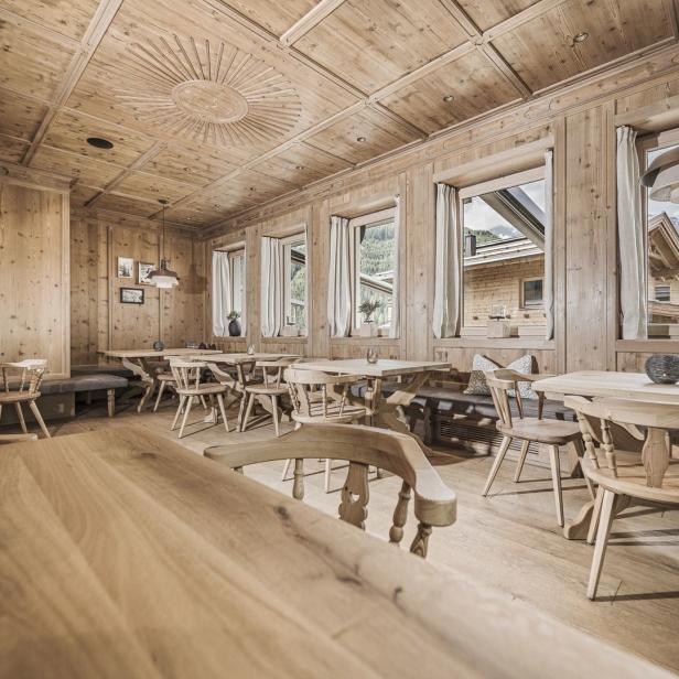 Innenansicht eines Restaurants mit Holztäfelung und Tischen.