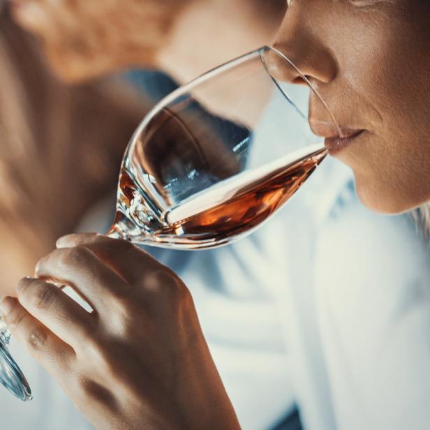 Eine Frau trinkt ein Glas Roséwein.