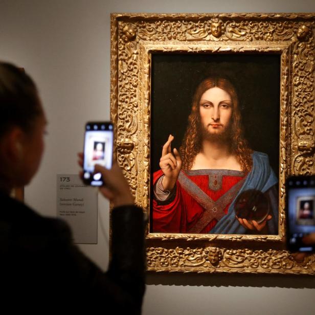 Besucher fotografieren das Gemälde „Salvator Mundi“ in einer Kunstausstellung.