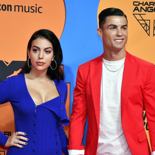 Cristiano Ronaldo und Georgina Rodríguez posieren auf einem orangefarbenen Teppich.