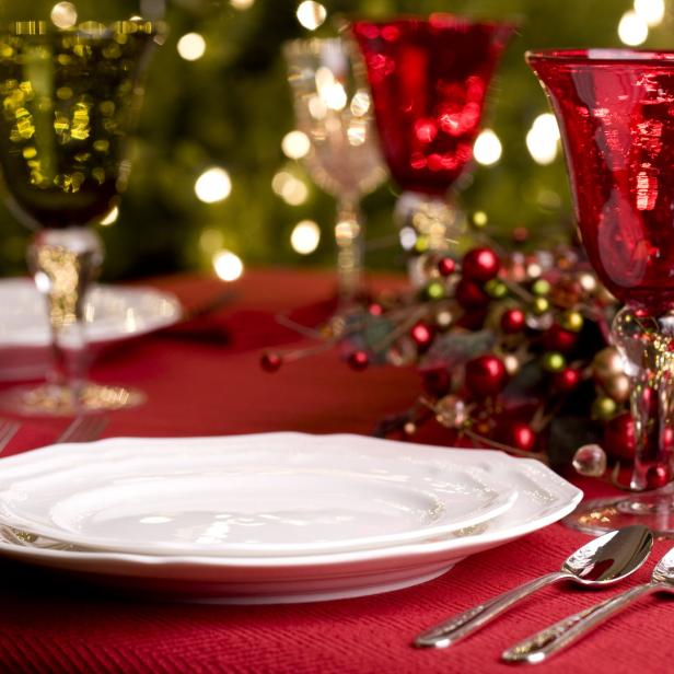 Ein festlich gedeckter Tisch mit Tellern, Gläsern und Weihnachtsdekoration.
