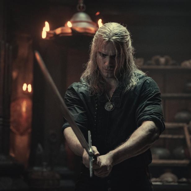 Geralt von Riva hält ein Schwert in den Händen.