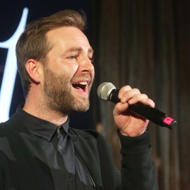 Josh hält ein Mikrofon und spricht.