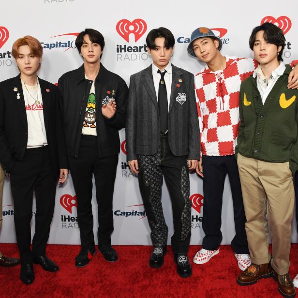 Die südkoreanische Boygroup BTS posiert auf einem roten Teppich vor Sponsorenlogos.