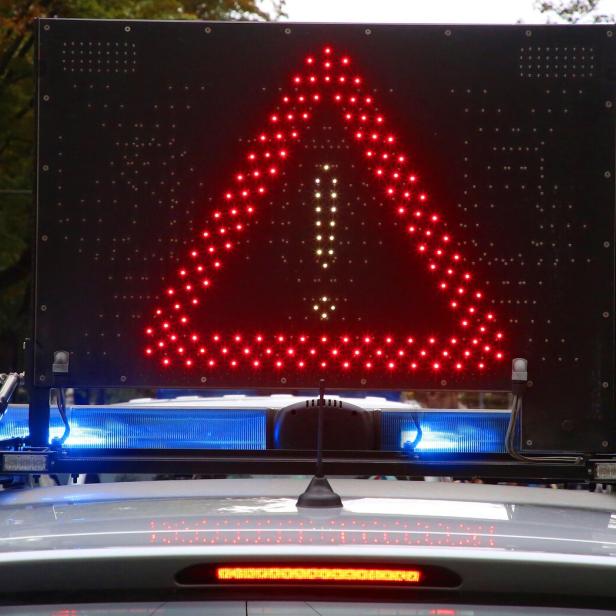 Ein Warnschild mit einem roten Dreieck und Ausrufezeichen auf dem Dach eines Fahrzeugs.