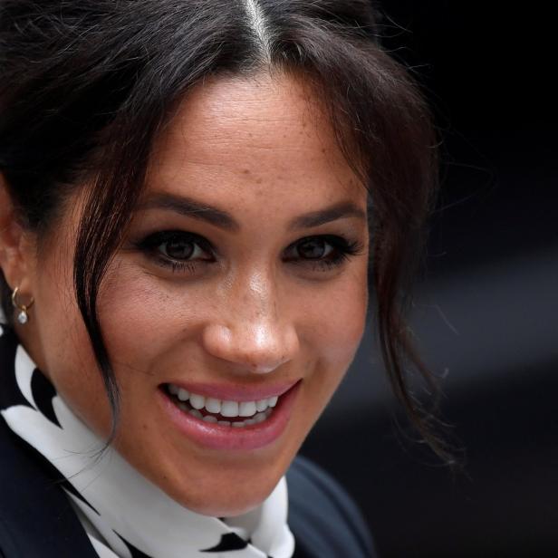 Ein Porträt von Meghan Markle, die lächelt und eine schwarz-weiße Halskette trägt.