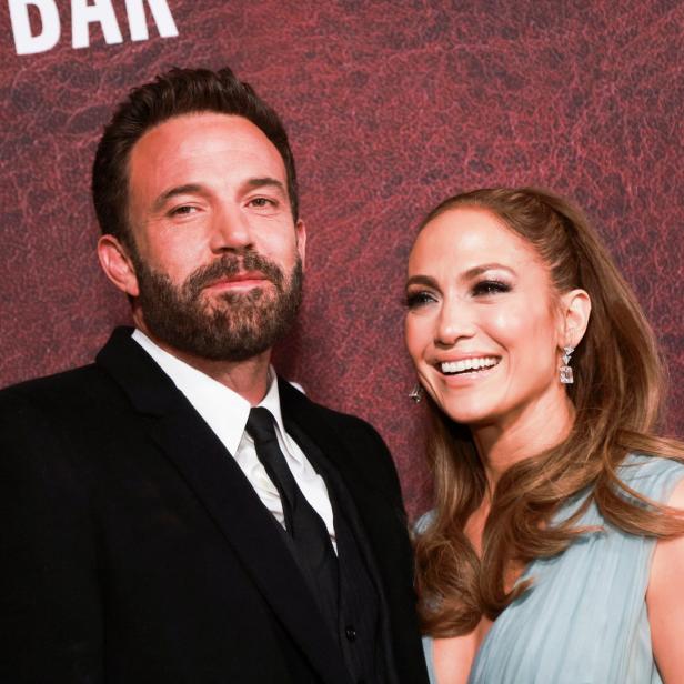 Ben Affleck und Jennifer Lopez posieren auf einem roten Teppich.