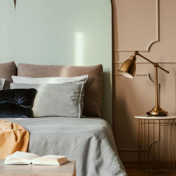 Ein Schlafzimmer mit einem Bett, einem Nachttisch und einer Lampe.