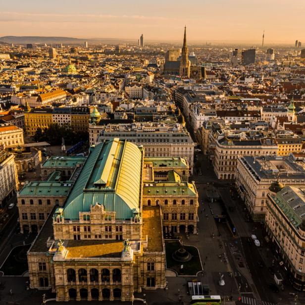 Luftaufnahme der Wiener Staatsoper und der umliegenden Stadtlandschaft bei Sonnenuntergang.