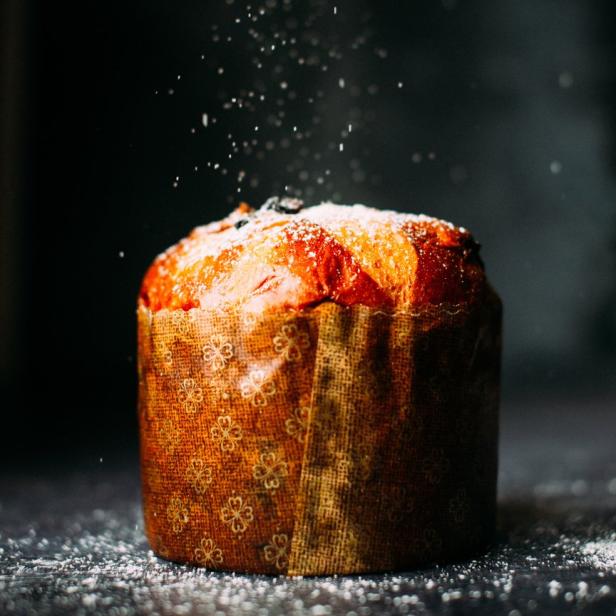 Ein Panettone wird mit Puderzucker bestreut.