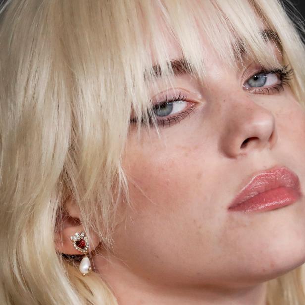 Nahaufnahme von Billie Eilish mit blonden Haaren und einem herzförmigen Ohrring.