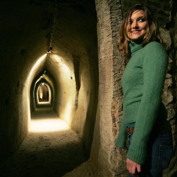 Eine Frau steht vor einem beleuchteten Tunnel.