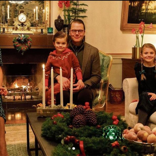 Die schwedische Kronprinzessin Victoria mit Familie vor einem Kamin zur Adventszeit.