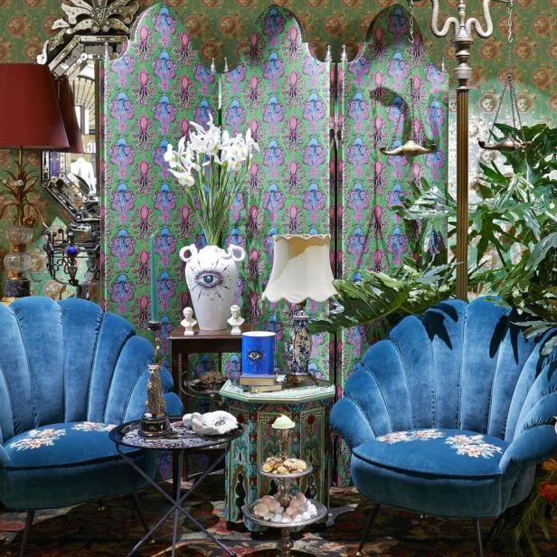 Ein opulent eingerichteter Raum mit blauen Muschelsesseln und floralen Mustern.