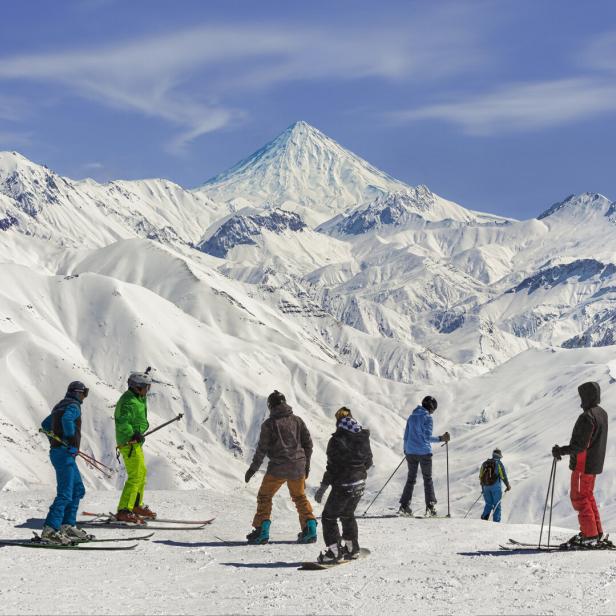 Wintersportler auf einer Piste über der Baumgrenze im Iran.