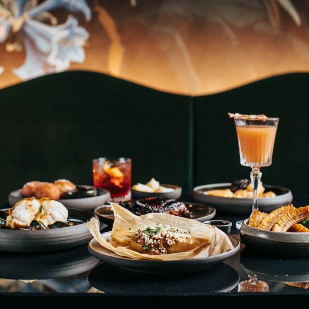 Eine Auswahl an Speisen und Getränken, darunter ein Tamale, Cocktails und Maiskolben.