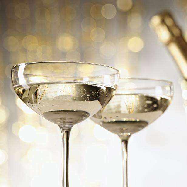 Zwei Gläser Sekt stehen vor einem Champagnerkühler.