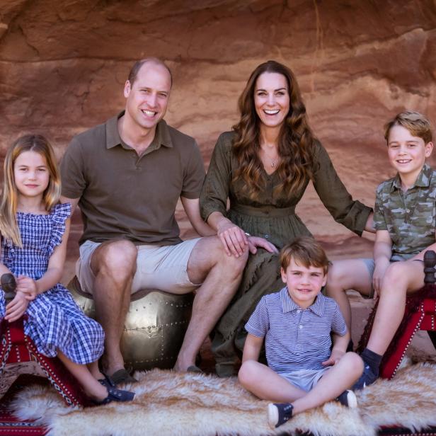 Prinz William, Prinzessin Kate und ihre Kinder posieren vor einer Felswand für ein Familienfoto.