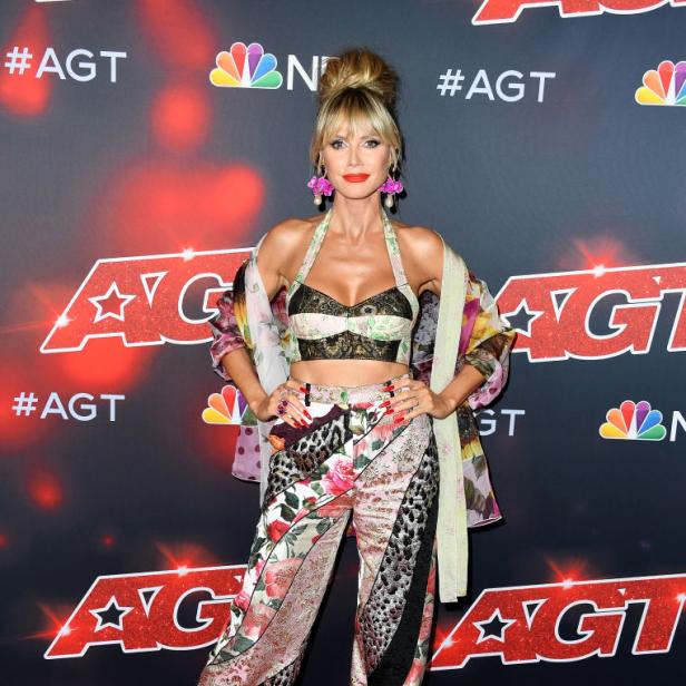 Heidi Klum posiert auf dem roten Teppich von „America's Got Talent“ in einem bunten Hosenanzug.