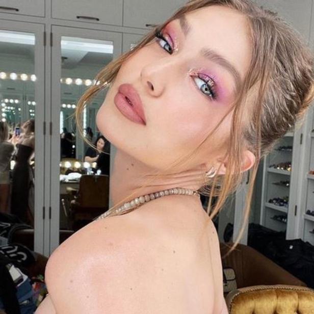 Gigi Hadid posiert mit rosa Lidschatten und hochgesteckten Haaren.