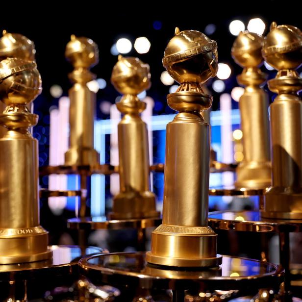 Mehrere goldene Golden Globe Awards stehen auf Tischen.