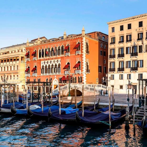 Gondeln liegen am Ufer vor dem Dogenpalast und dem Hotel Danieli in Venedig.
