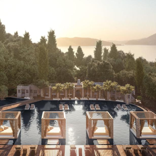 Ein Luxusresort mit Pool, Cabanas und Blick auf das Meer und bewaldete Hügel.