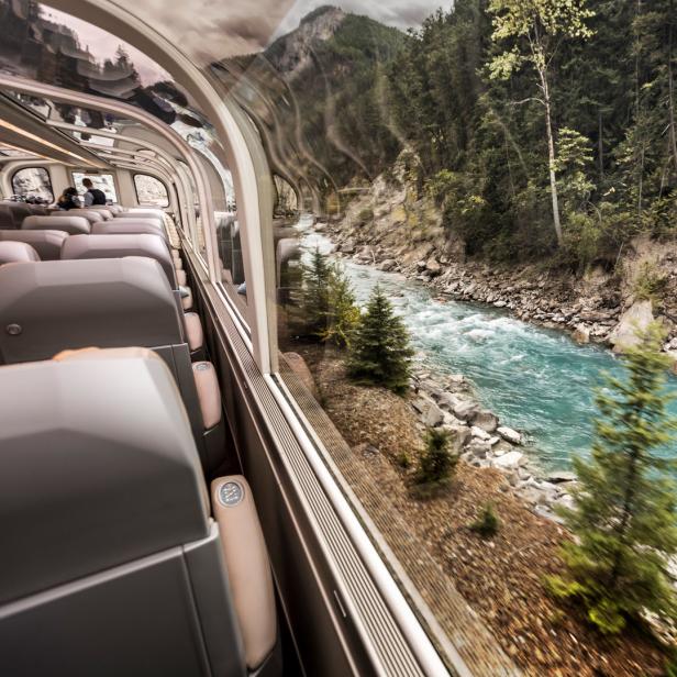 Blick aus dem Rocky Mountaineer Zug auf einen türkisfarbenen Fluss in den kanadischen Rockies.
