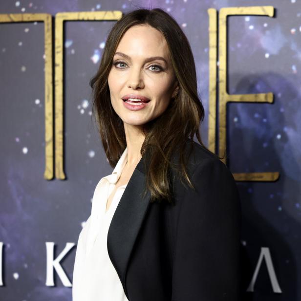 Angelina Jolie posiert vor dem Hintergrund des Films „Eternals“.