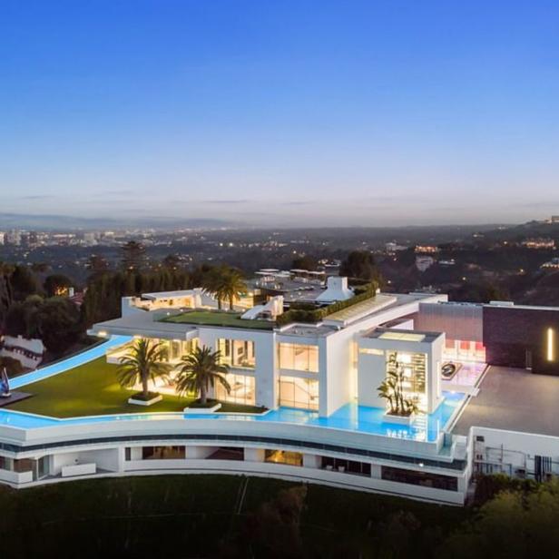Ein modernes, luxuriöses Haus mit Pool auf dem Dach und Blick auf die Stadt.