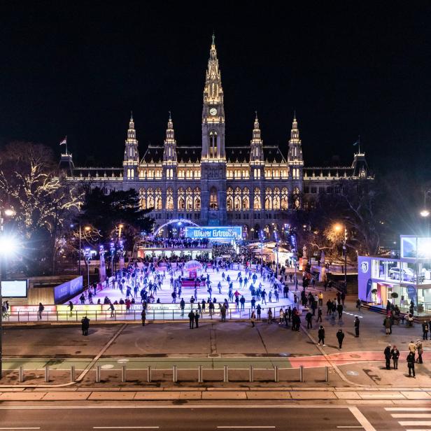 Der Wiener Eistraum vor dem beleuchteten Rathaus in der Nacht.