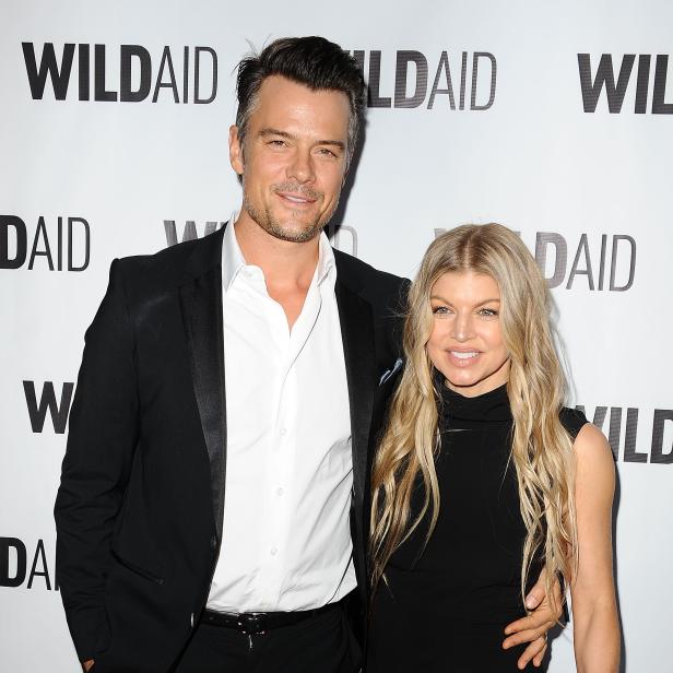 Fergie und Josh Duhamel posieren vor einer Wand von WildAid.
